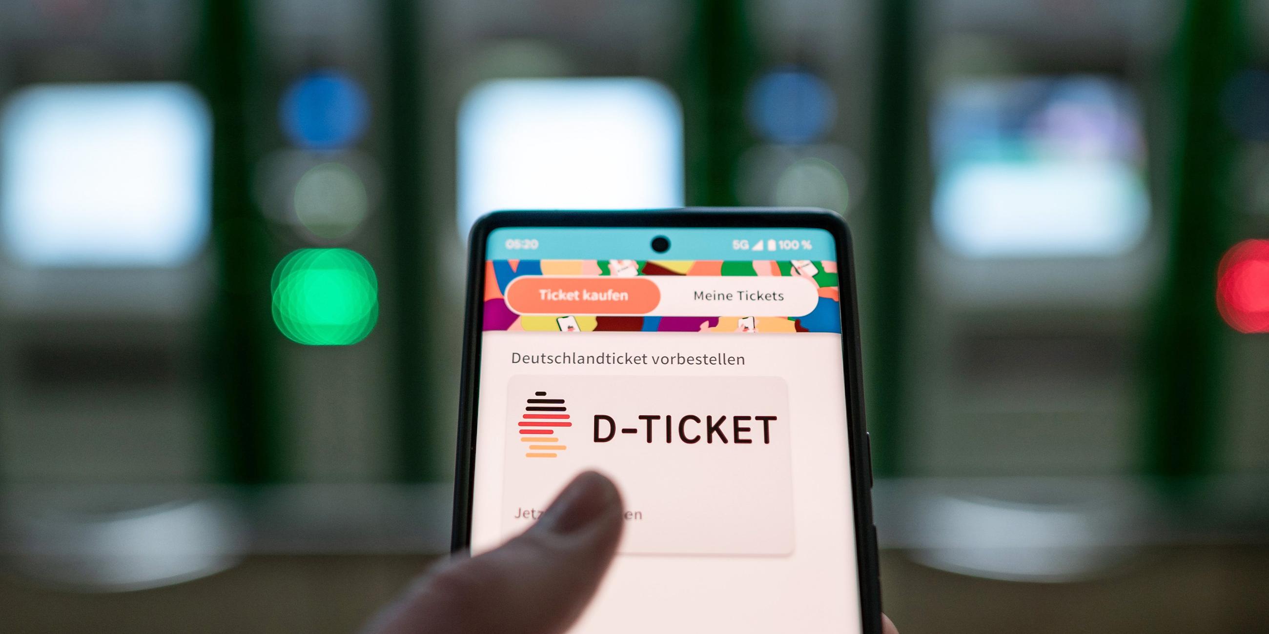 Archiv: Ein Mann hält ein Mobiltelefon, auf dem das «D-Ticket» gekauft werden kann, vor Ticketautomaten am Hauptbahnhof in der Hand