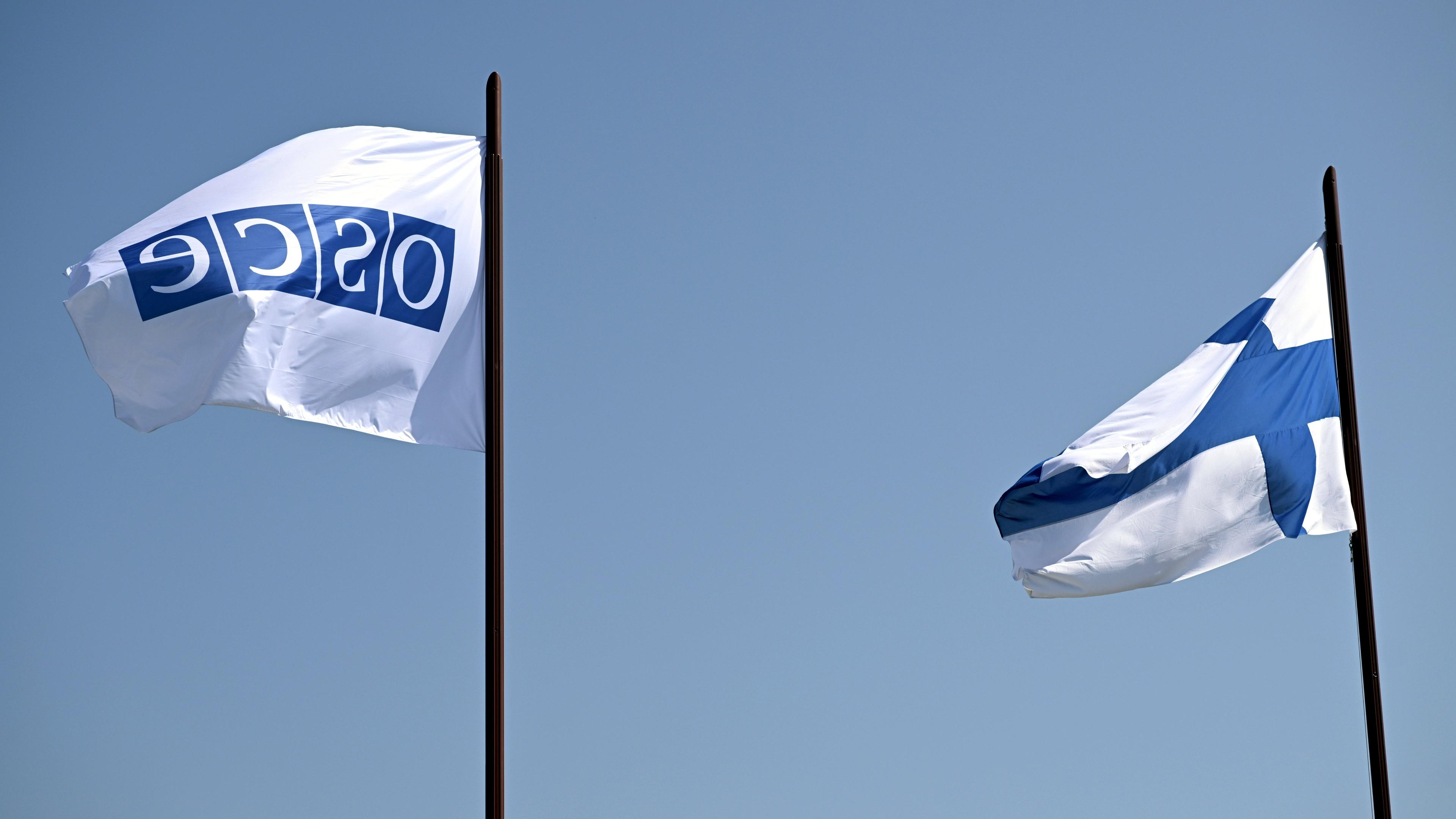 OSZE- und finnische Flaggen wehen vor der Finlandia-Halle, in der am 31. Juli 2025 die Helsinki+50-Konferenz in Helsinki, Finnland, stattfindet