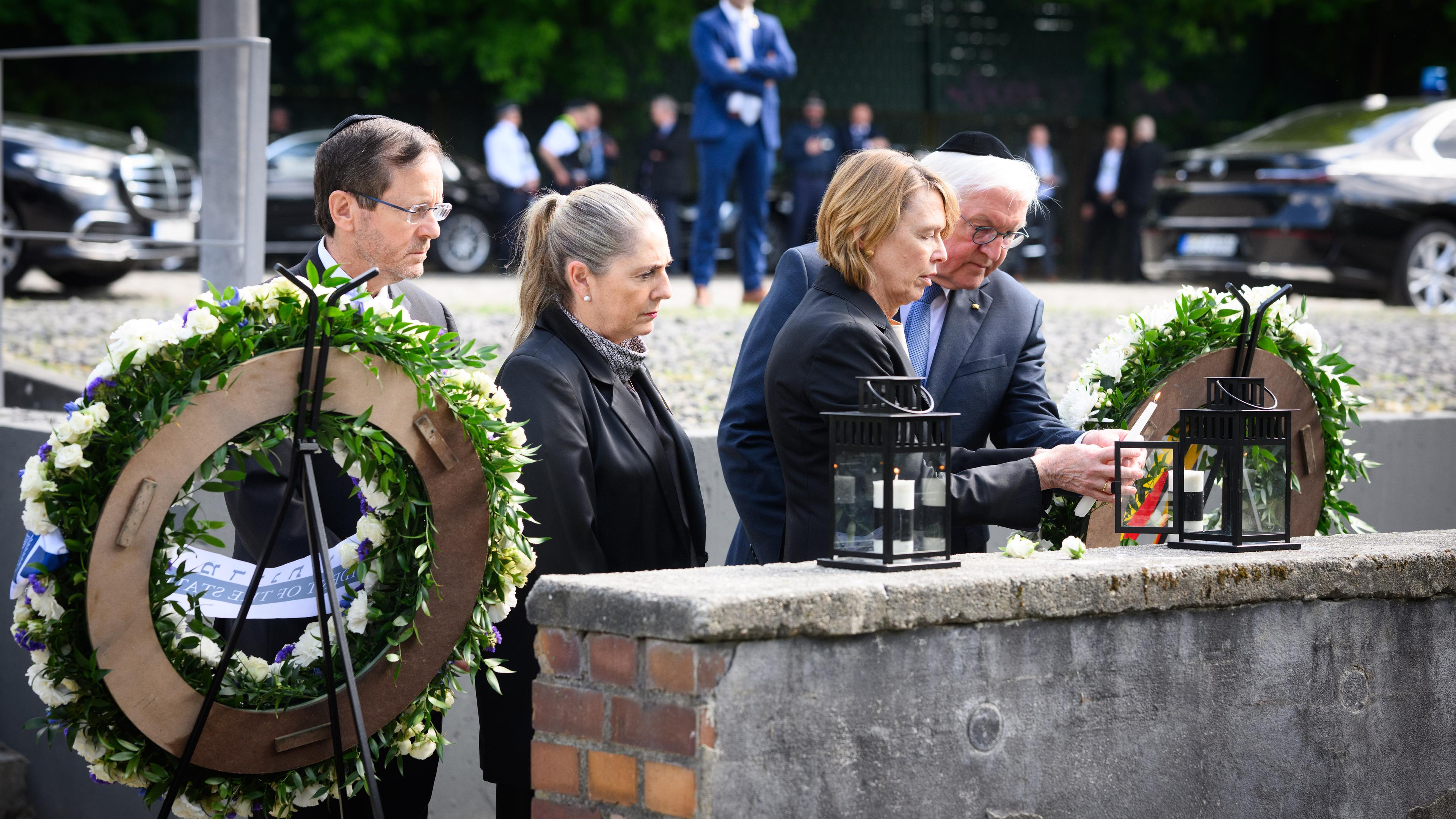 Bundespräsident Frank-Walter Steinmeier (r) und seine Frau Elke Büdenbender (2.v.r.) besuchen zusammen mit Izchak Herzog (l), Präsident von Israel, und seiner Frau Michal Herzog zu einem gemeinsamen Gedenken das Mahnmal Gleis 17 in Berlin und zünden dort Kerzen an