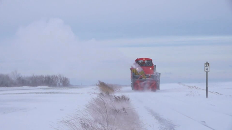 Die rote 80 Tonnen schwere Schneeschleuder fräst sich ihren Weg durch die verschneite Bahnstrecke.