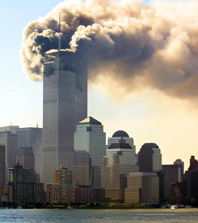 Panorama von Manhattan am 11. September 2001 mit Fokus auf das World Trade Center, dessen oberer Bereich von einer massiven Rauchwolke umhüllt ist.