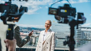 Alice Weidel "Berlin direkt - Sommerinterview 2026": Alice Weidel steht auf einer Terrasse, TV Kameras stehen vor ihr.