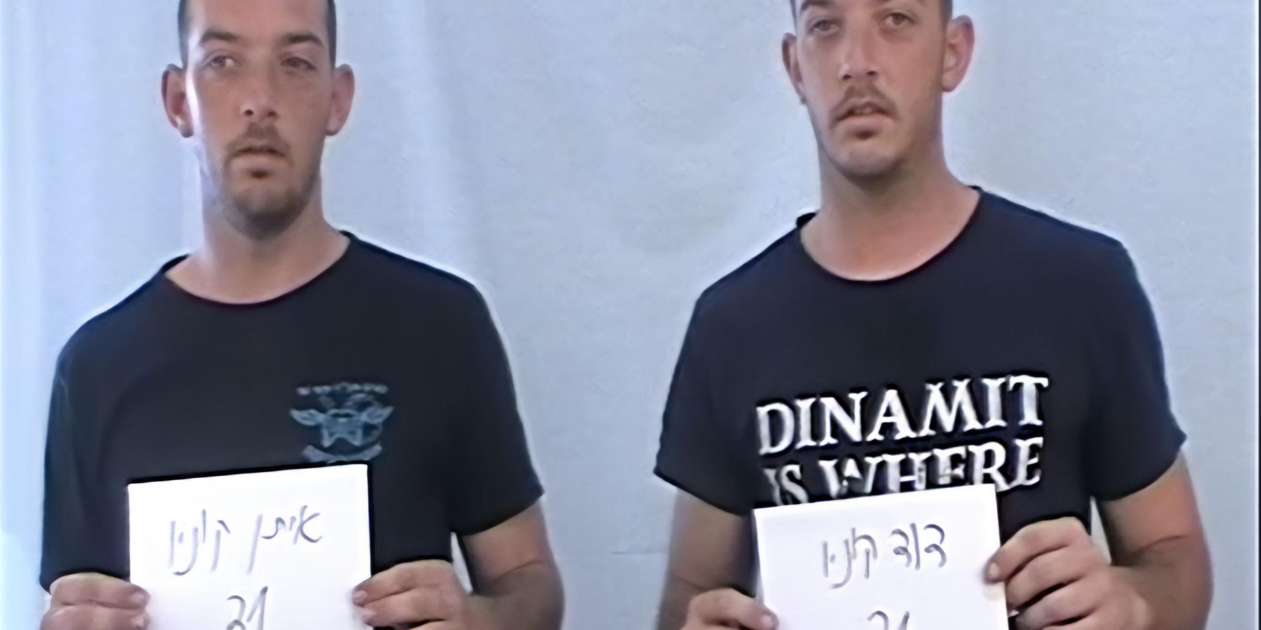 Zwei gleich aussehende Zwillings-Männer in T-Shirts stehen nebeneinander und halten Zettel mit Nummern hoch.
