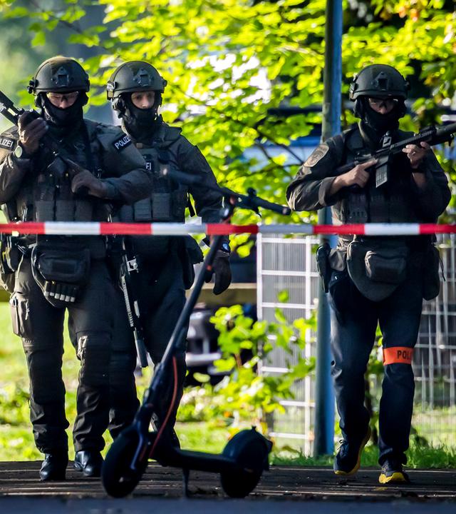 Bewaffnete Polizeibeamte patrouillieren in der Nähe der Pferderennbahn Schachen in Aarau.