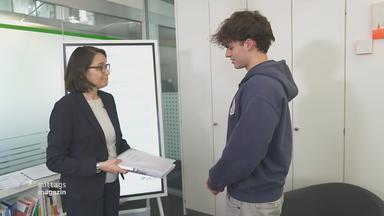 Schülerinnen und Schüler schreiben in einem großen Raum ihre Abiprüfung 