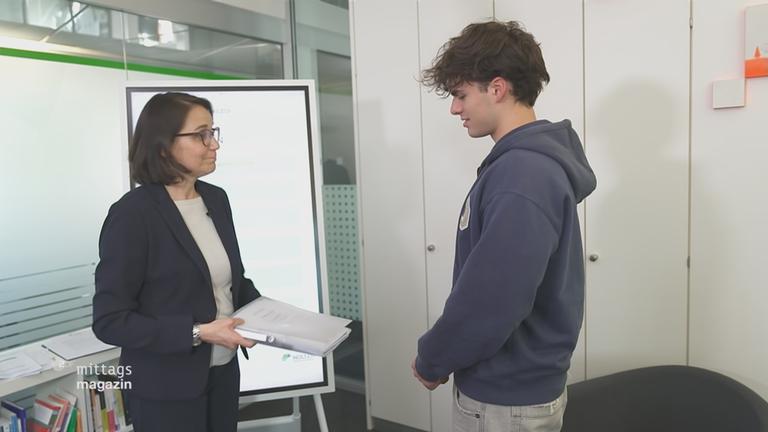 Schülerinnen und Schüler schreiben in einem großen Raum ihre Abiprüfung 