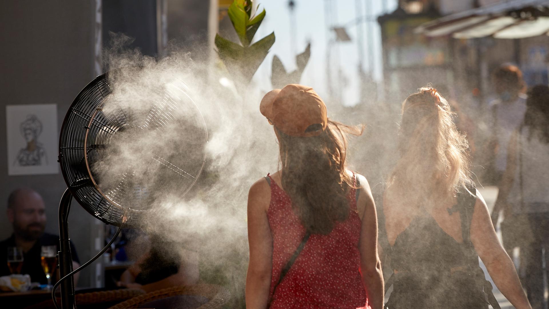 (Symbolfoto) Eine Frau kühlt sich mit einem Wasserdampfdeffusor ab.