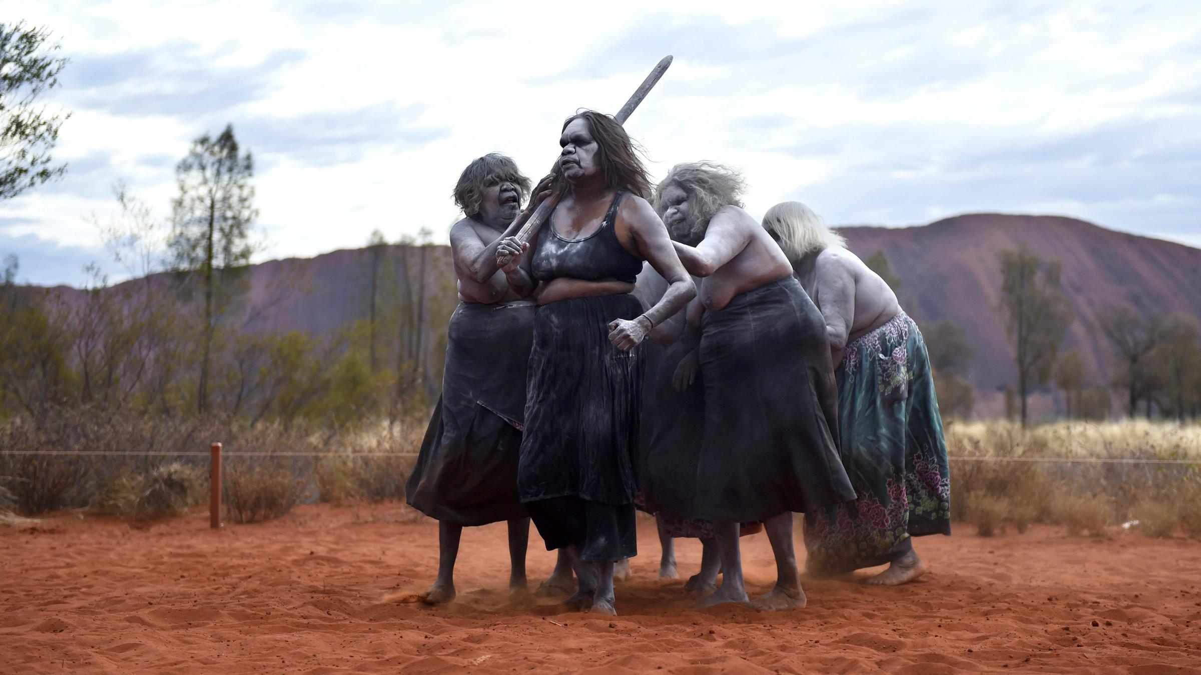 Aborigines bei einem traditionellen Tanz vor dem Uluru in Australien
