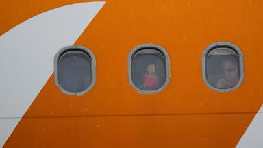 Aus den Vereinigten Staaten abgeschobene venezolanische Migranten schauen nach der Landung aus den Bullaugen ihres Flugzeugs.