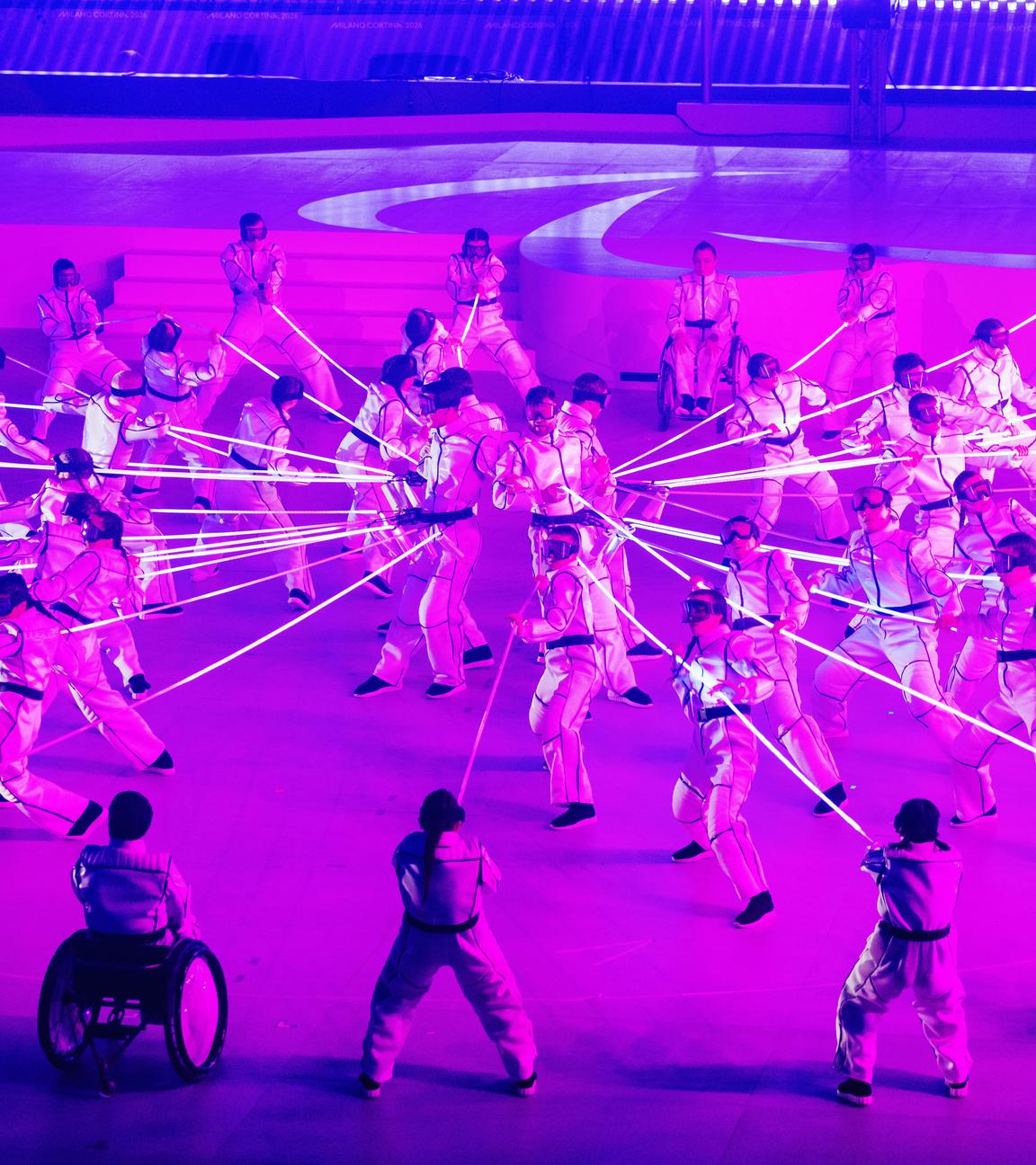 Künstler performen während der Abschlussfeier der Paralympics unter rosafarbenem Licht.
