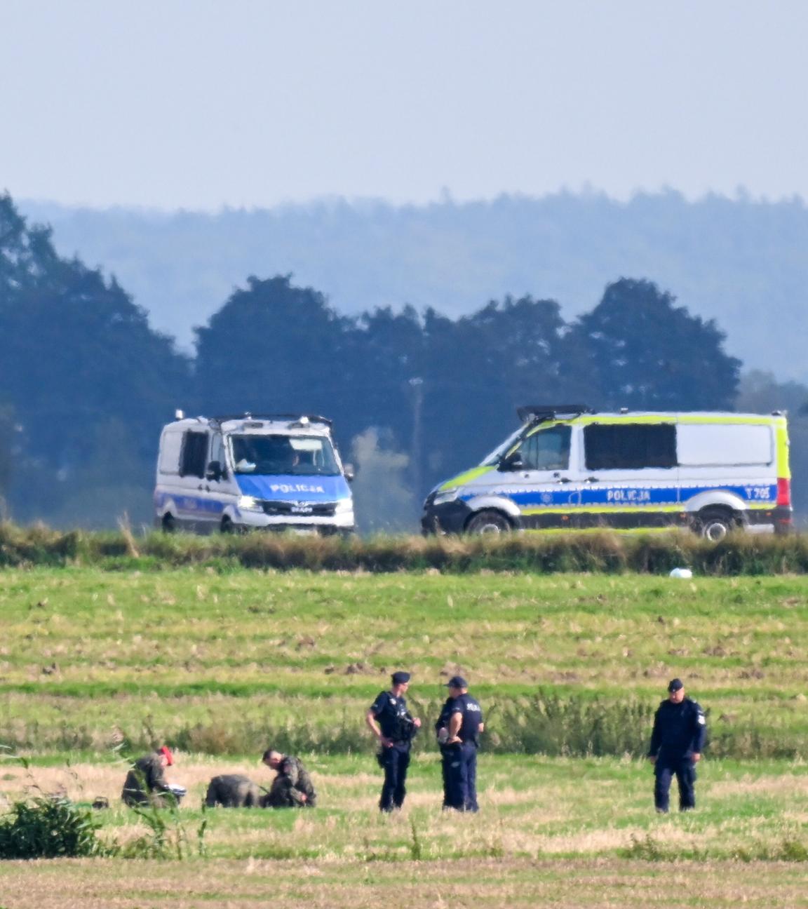 Polen: Polizisten untersuchen Zeile der abgeschossenen russischen Drohne auf einem Feld.