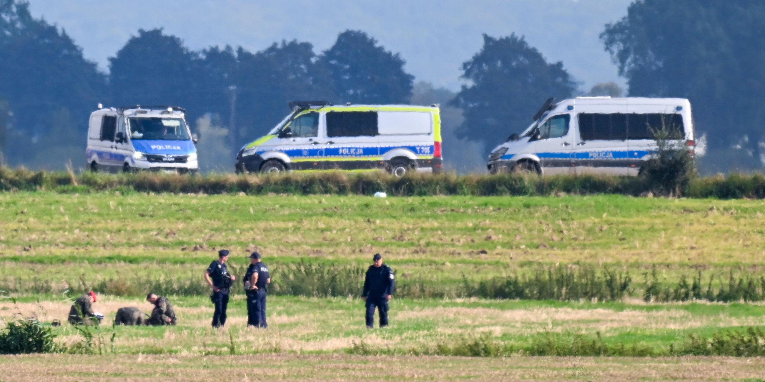 Polen: Polizisten untersuchen Zeile der abgeschossenen russischen Drohne auf einem Feld.