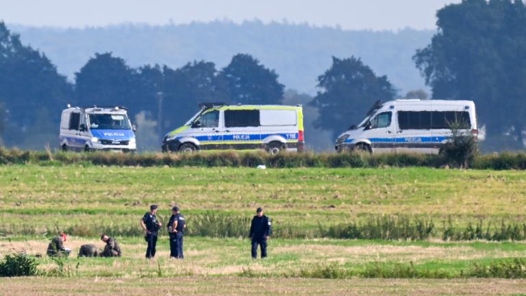 Polen: Polizisten untersuchen Zeile der abgeschossenen russischen Drohne auf einem Feld.