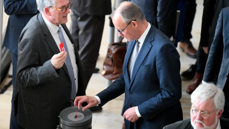 Friedrich Merz wirft seine Abstimmkarte in die Wahlurne ein. Im Bundestag wird über ein Sondervermögen abgestimmt.