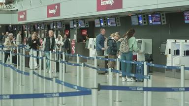 Reisende am Flughafen vor Eurowings-Schalter