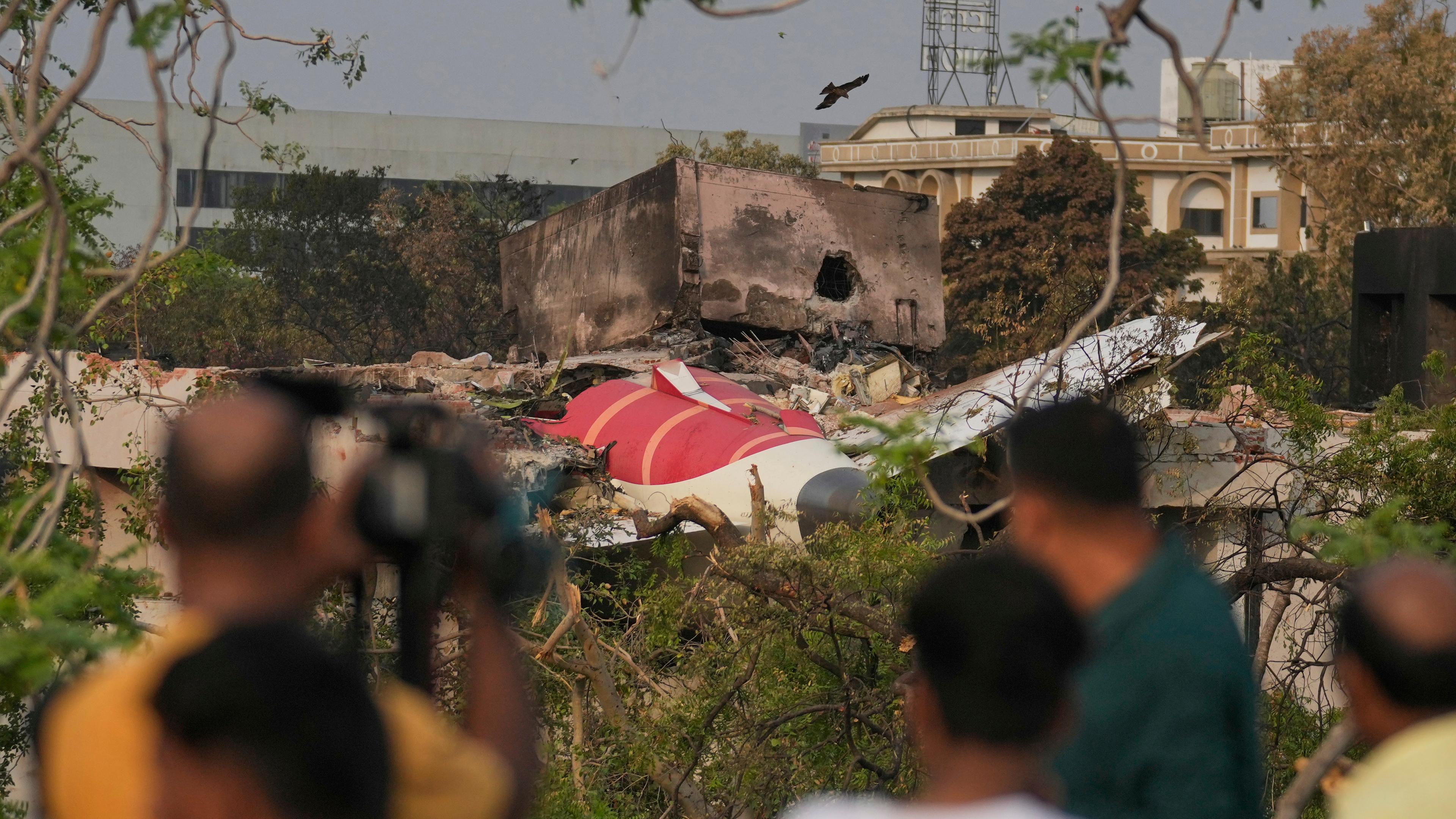 Menschen betrachten die Wrackteile des abgestürzten Flugzeugs von Air India. 