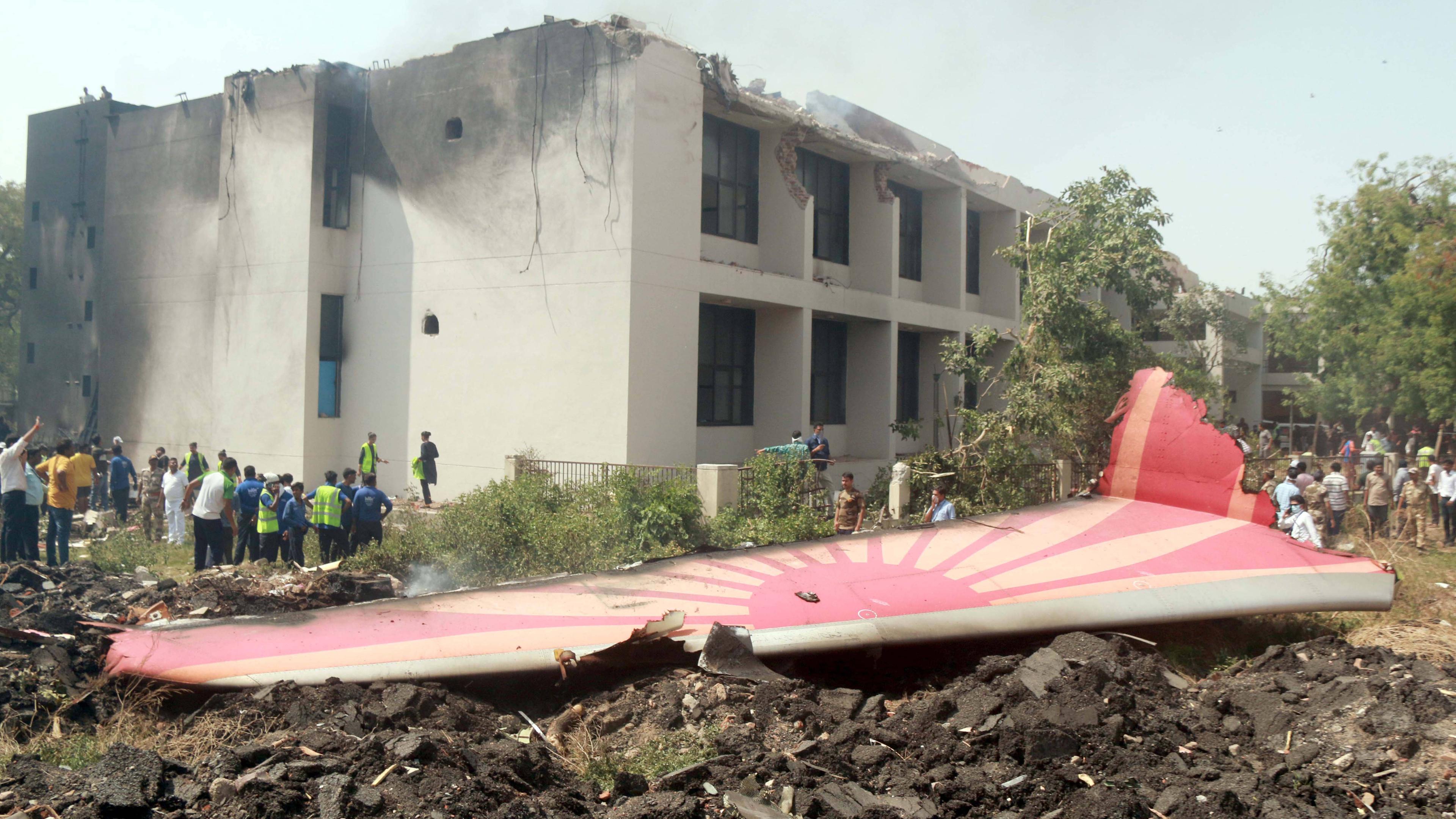 Menschen betrachten die Trümmer eines abgestürzten Air India-Flugzeugs in Ahmedabad im indischen Bundesstaat Gujarat