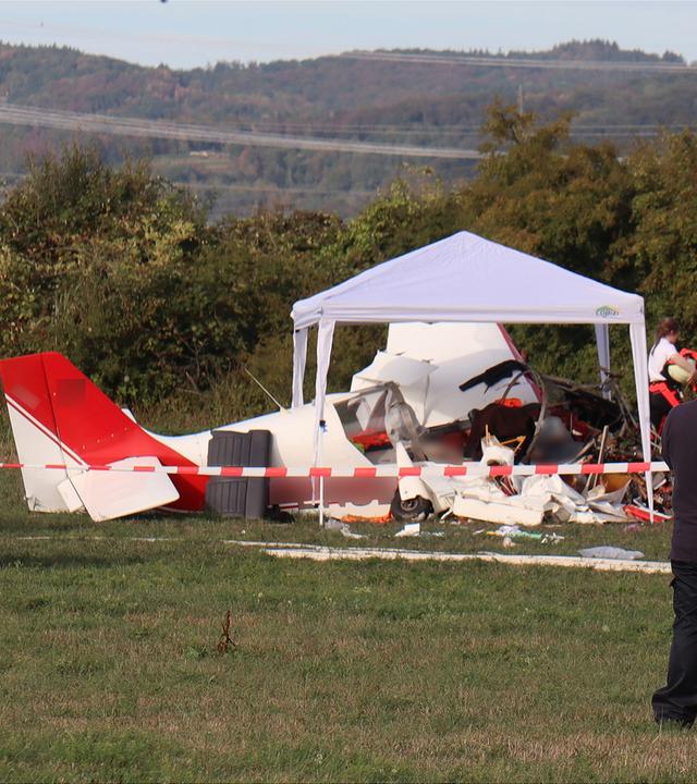 Rettungskräfte sind nach einem schweren Unfall am Rande einer Flugschau neben dem Wrack eines abgestürzten Kleinflugzeugs im Einsatz.
