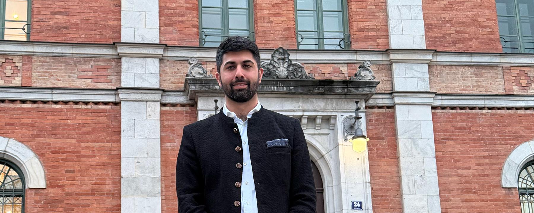 Der neue Oberbürgermeister von Rosenheim, Abuzar Erdogan, steht vor einem Gebäude.