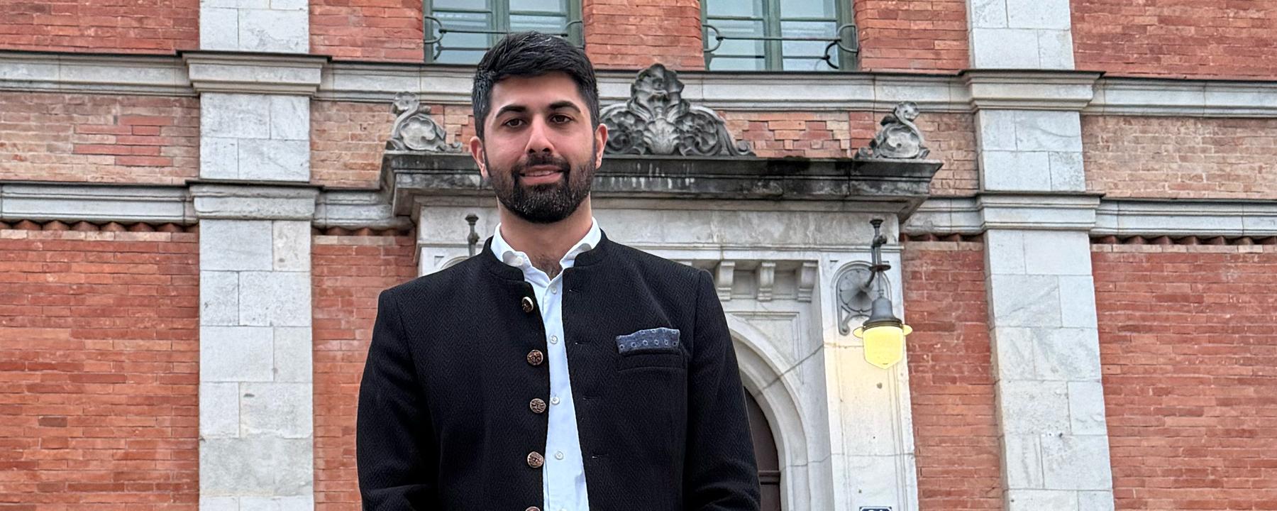 Der neue Oberbürgermeister von Rosenheim, Abuzar Erdogan, steht vor einem Gebäude.