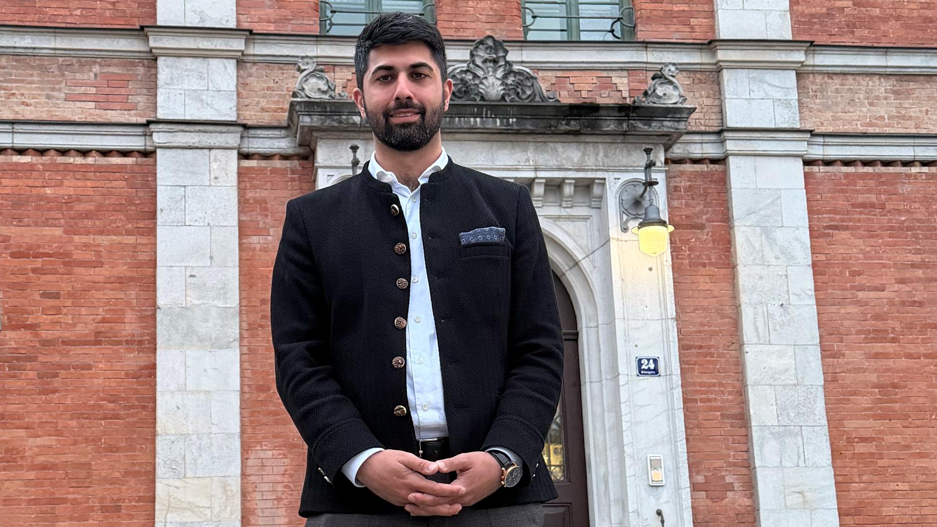 Der neue Oberbürgermeister von Rosenheim, Abuzar Erdogan, steht vor einem Gebäude.