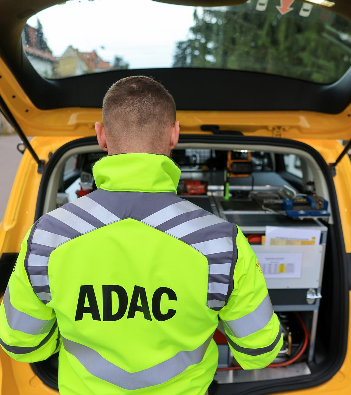Sachsen, Leipzig: Ein ADAC-Pannenhelfer steht nach einer Pannenhilfe am Kofferraum seines Fahrzeugs