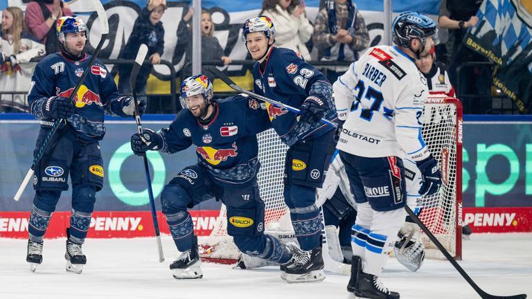 Die Eishockeyspieler Adam Brooks (links) und Alberts Smits (rechts) freuen sich mit Tobias Rieder (Mitte) der Red Bull München über dessen Tor zum 5:2 gegen ERC Ingolstadt am 29.03.2026.