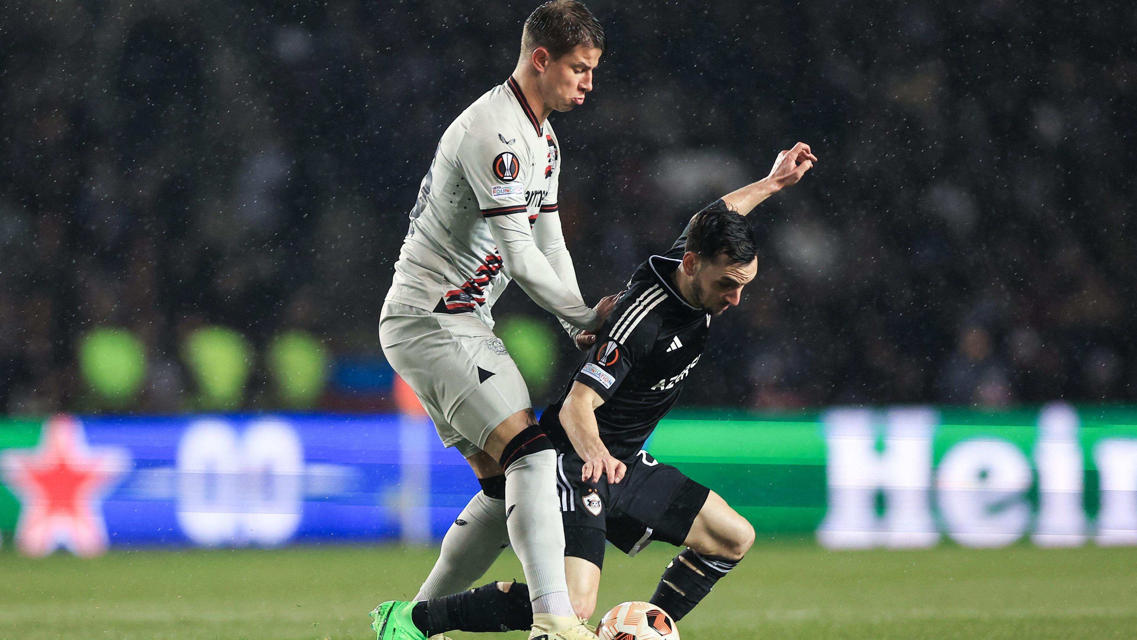 Adam Hlozek kämpft mit Marko Jankovic während des UEFA-Europa-League-Achtelfinal-Hinspiels zwischen Qarabag FK und Bayer 04 Leverkusen am 07.03.2024. 