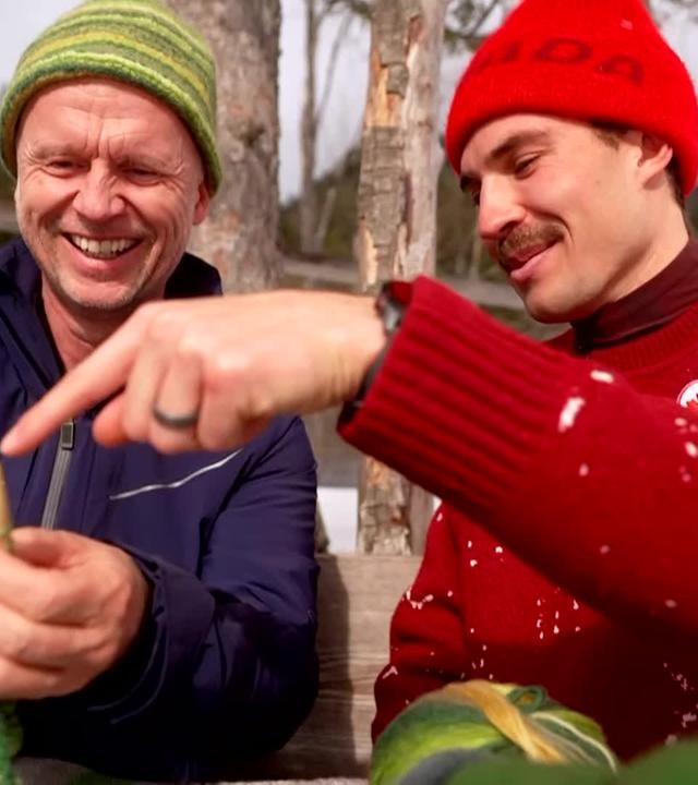 Der kanadische Biathlet Adam Runnalls strickt zusammen mit dem ZDF-Reporter Alex Ruda in Antholz