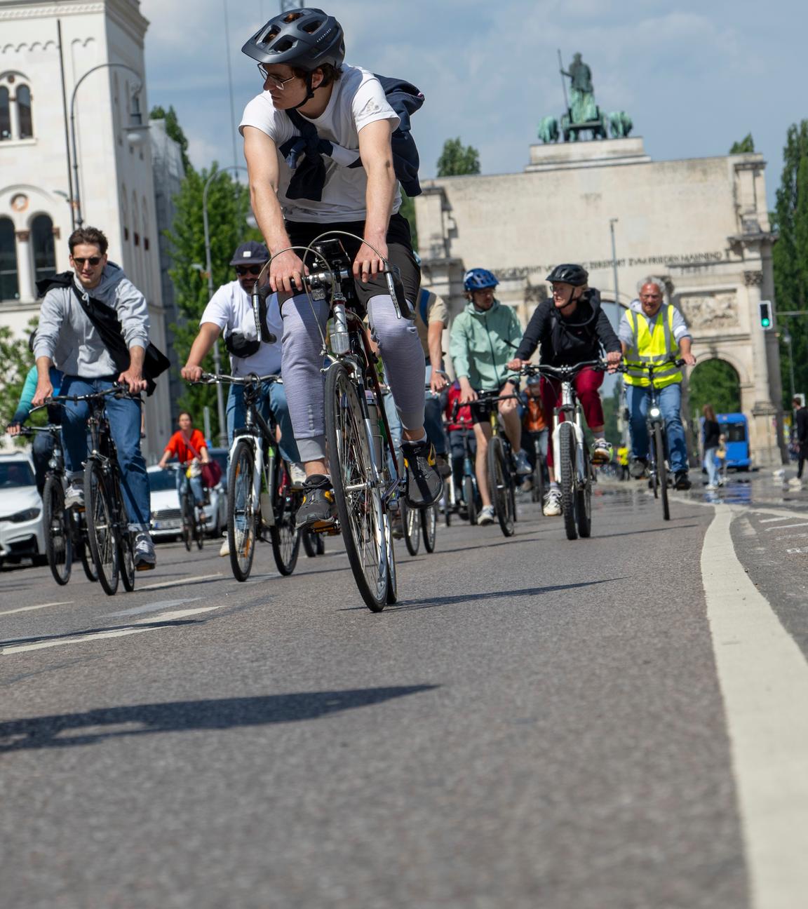 18.05.2025, Bayern, München: Vor dem Siegestor fahren Radler über die Leopoldstraße.