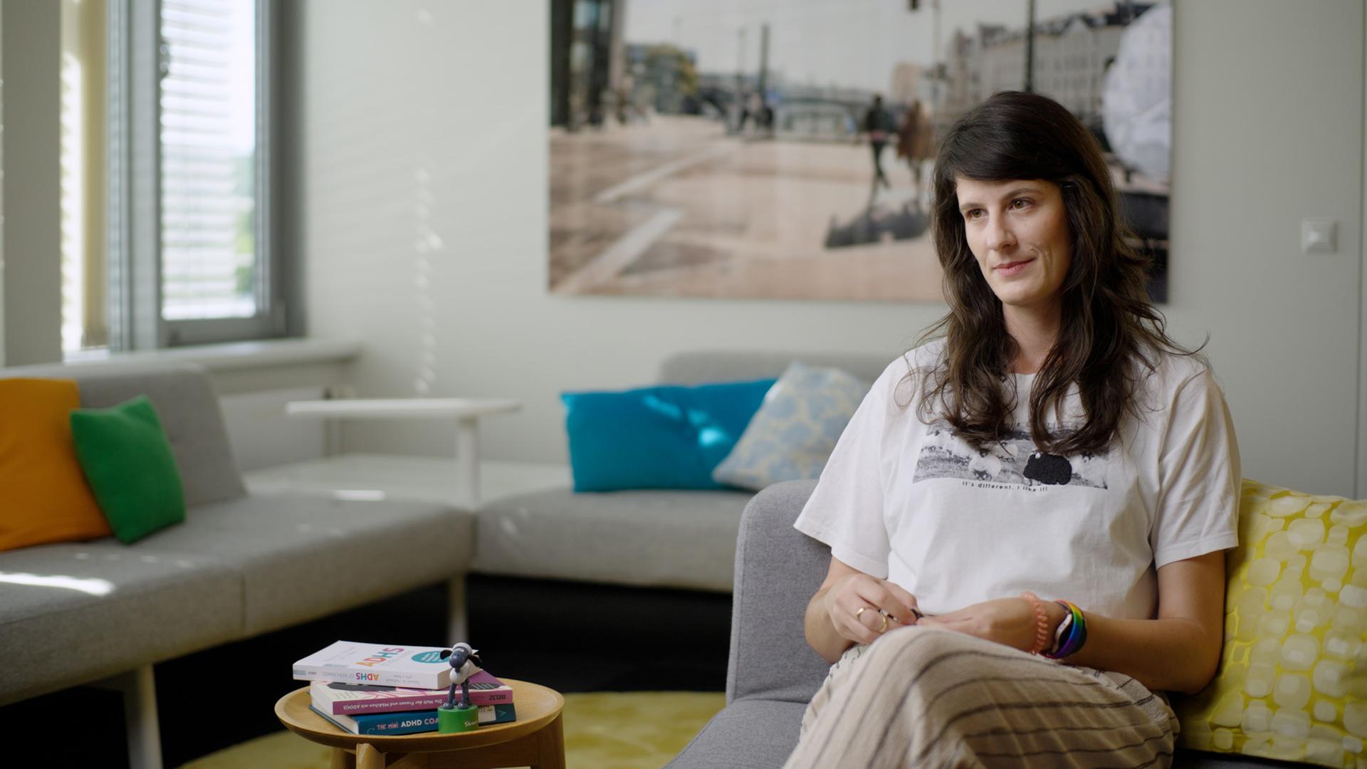 Standbild aus der Sendung "ADHS als Gamechanger": EineFrau sitzt auf einem Sofa, im Hintergrund ein leeres Sofa.