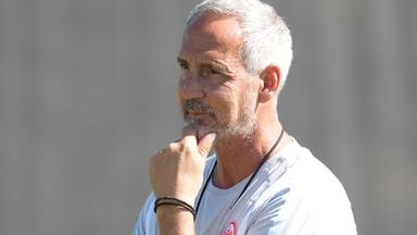 Adi Hütter beim Training von Eintracht Frankfurt, er hält seine linke hand an seinem Kinn.