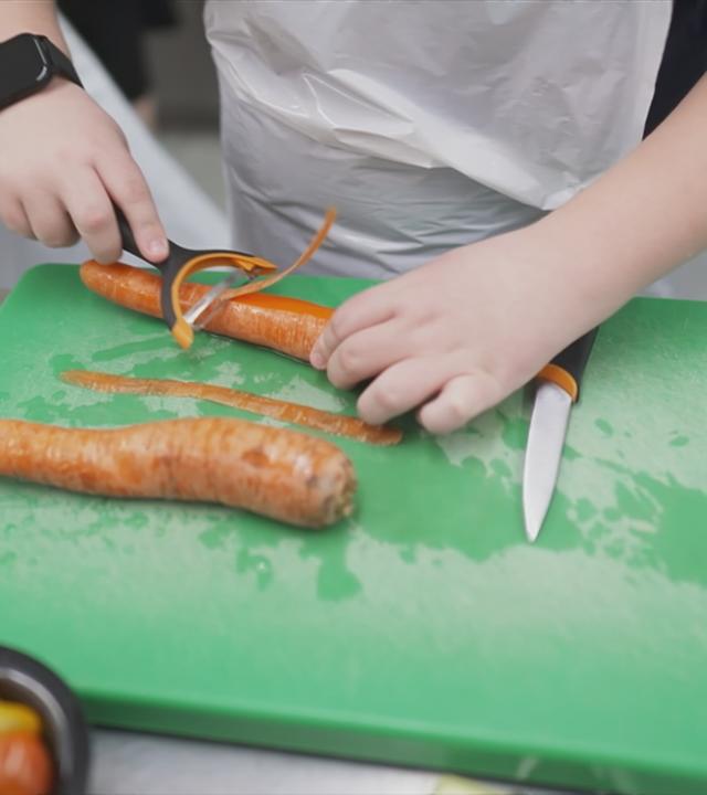 Kind schält Karotte