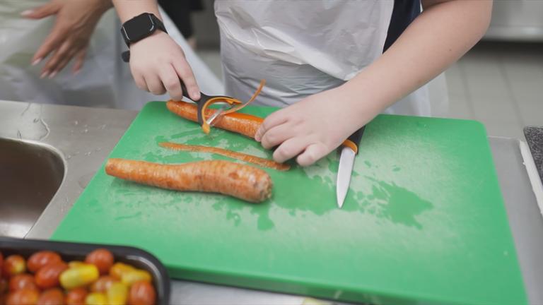 Kind schält Karotte