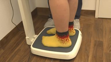 Adipositas - kräftiges Kind auf der Waage