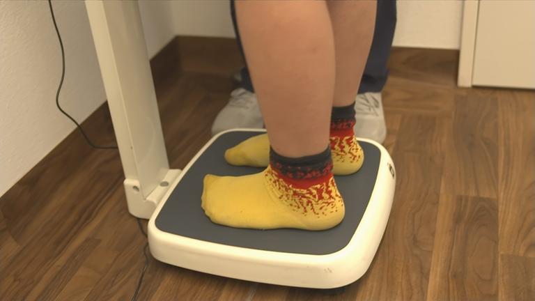 Adipositas - kräftiges Kind auf der Waage