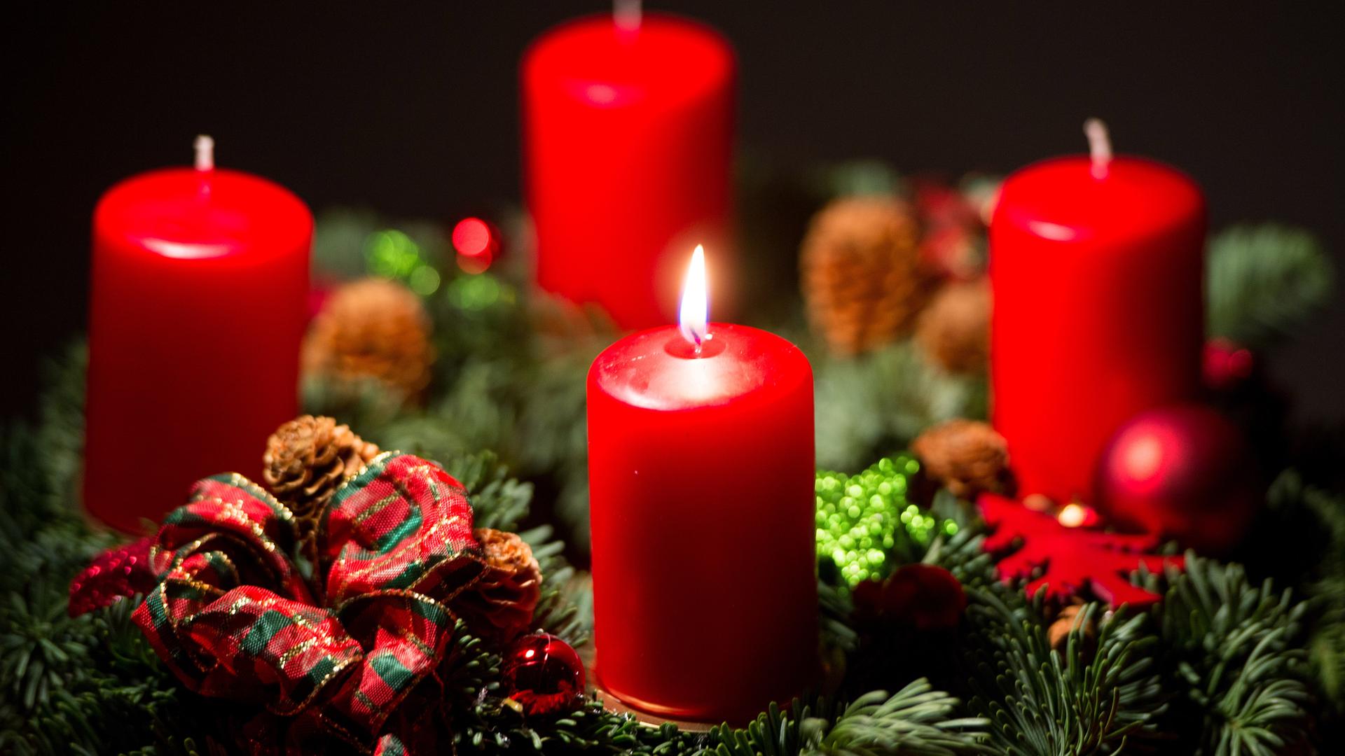 Eine Kerze brennt auf einem Adventskranz