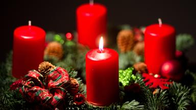Eine Kerze brennt auf einem Adventskranz