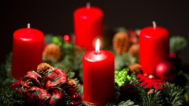 Eine Kerze brennt auf einem Adventskranz