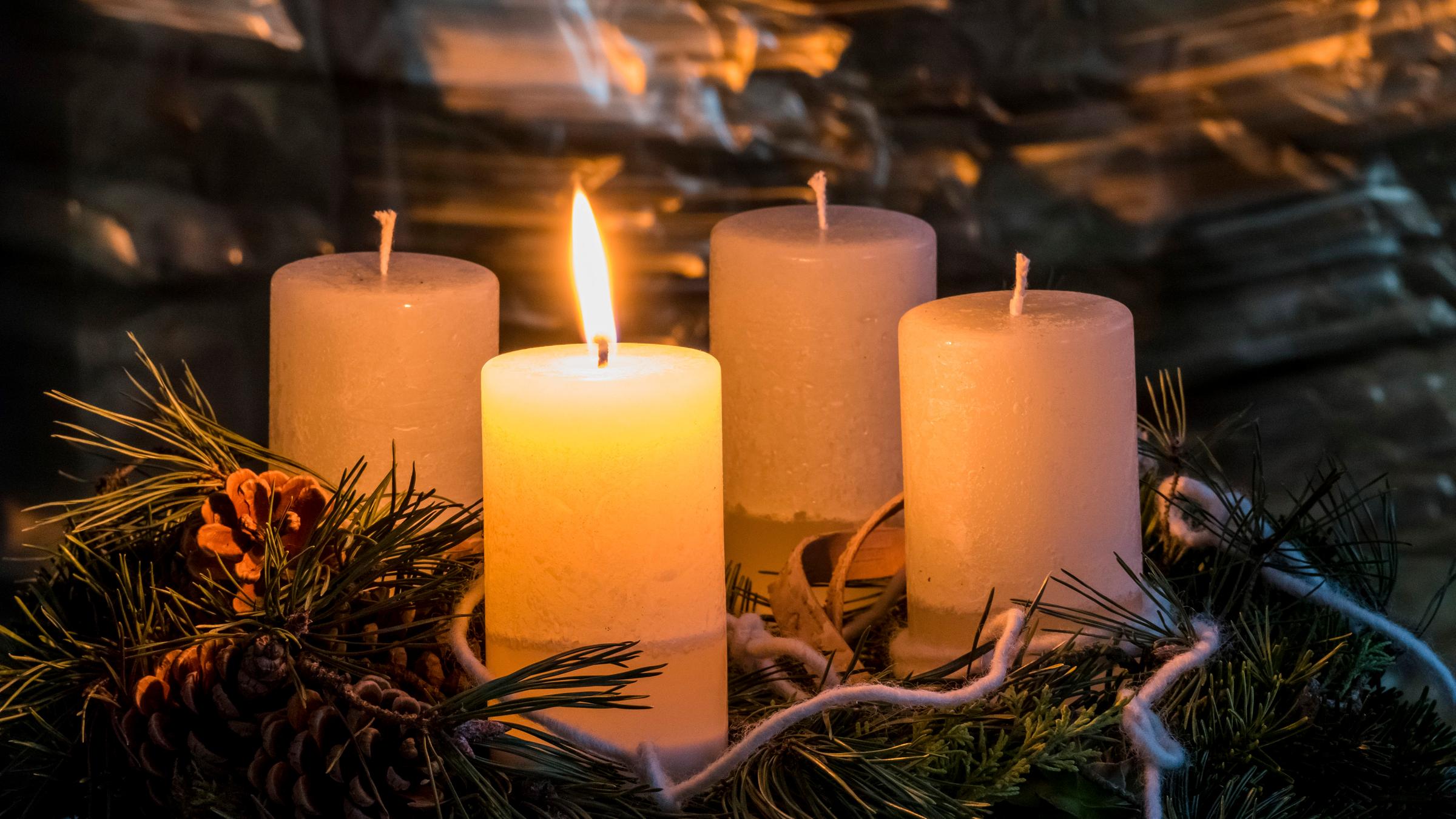 Adventskranz mit einer brennenden Kerze