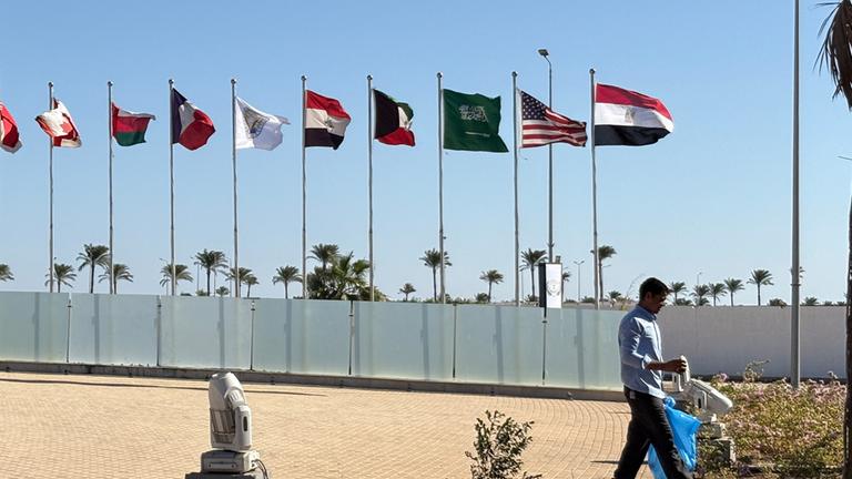 Ein Mann geht an Flaggen vorbei