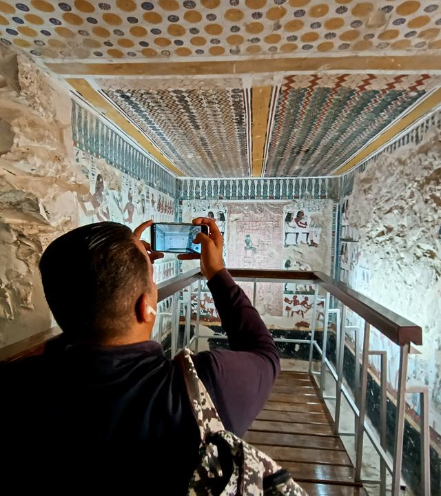  Ein Besucher fotografiert im Inneren des kürzlich restaurierten antiken Grabes des Amenhotep in der Nekropole von El-Khokha am Westufer des Nils in Luxor, Ägypten.