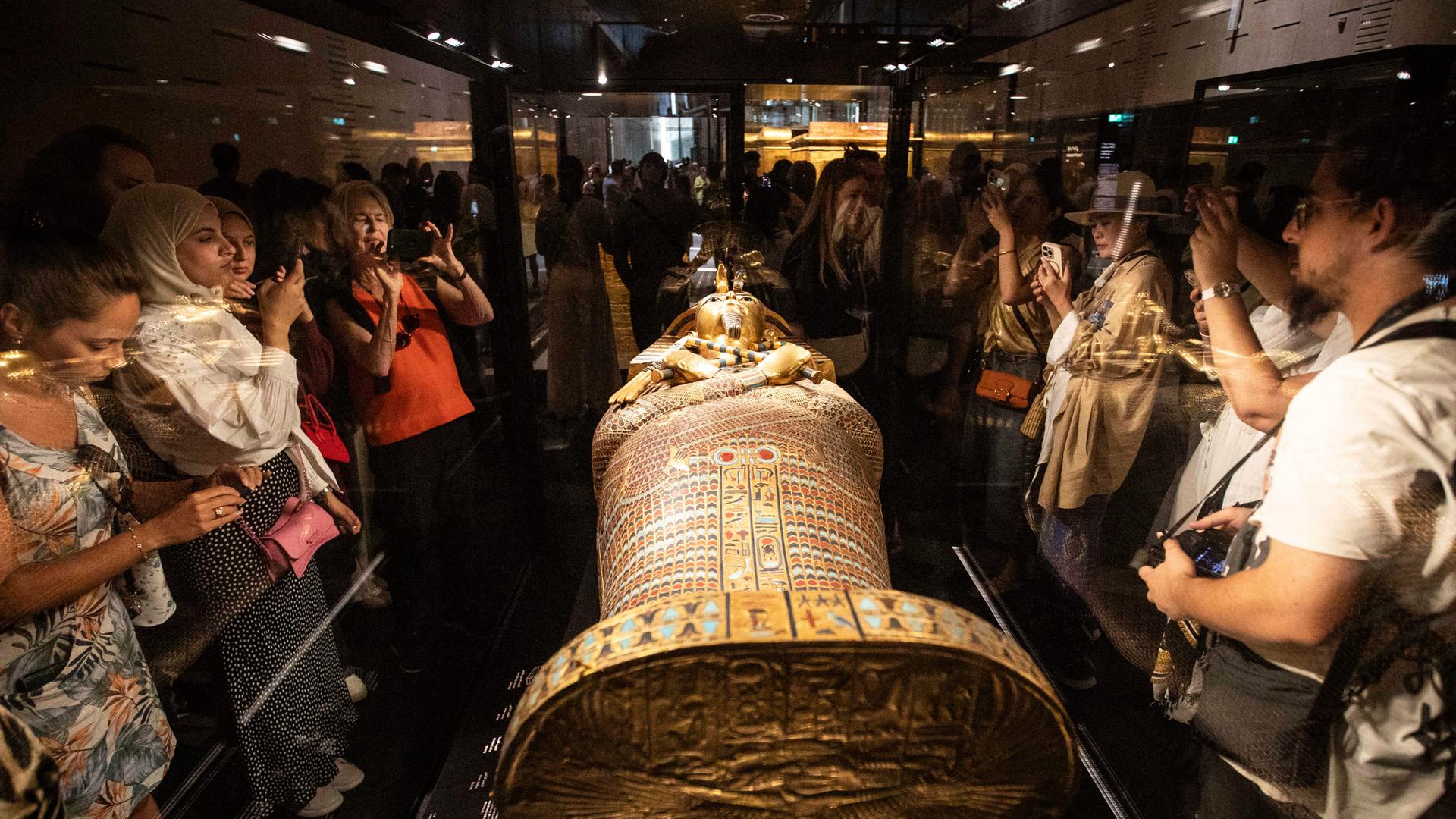 Besucher betrachten einen Sarkophag des altägyptischen Königs Tutanchamun.