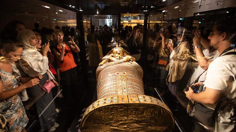 Besucher betrachten einen Sarkophag des altägyptischen Königs Tutanchamun.