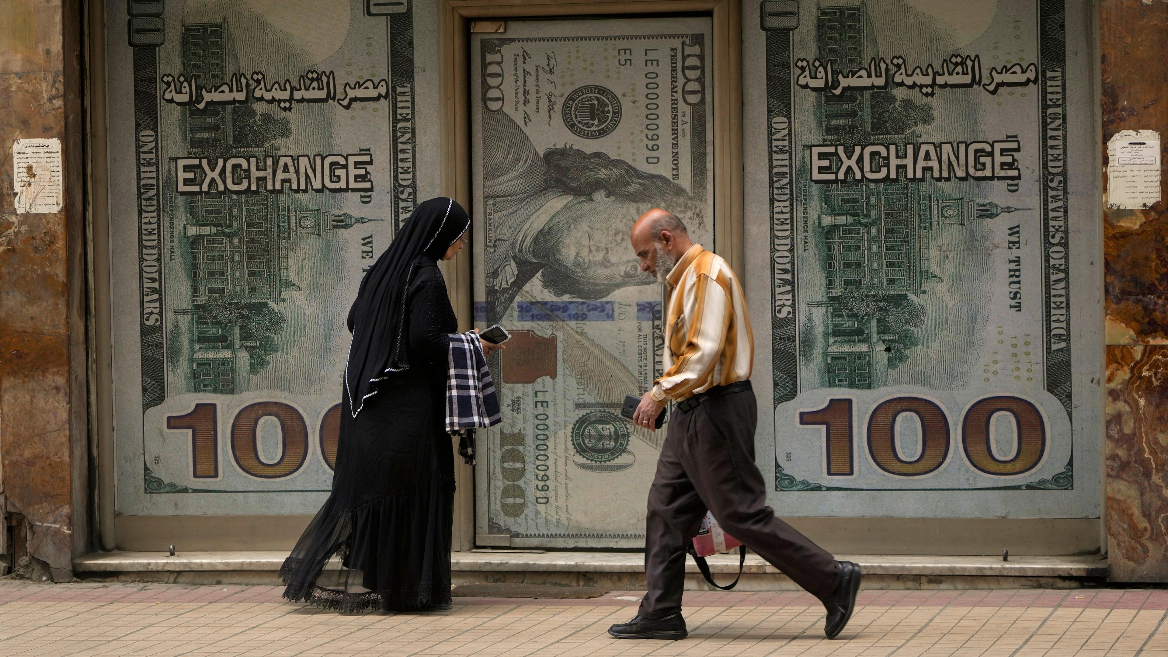 Ägypter gehen an einer Wechselstube in Kairo, Ägypten, vorbei.