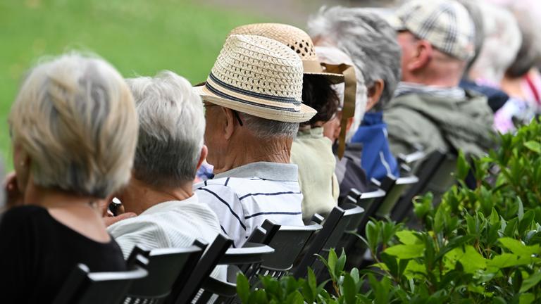 Ältere Menschen sitzen im Kurpark - Symbolfoto