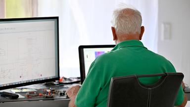 Ein Senior arbeitet in seiner Elektronik-Werkstatt im Home-Office.