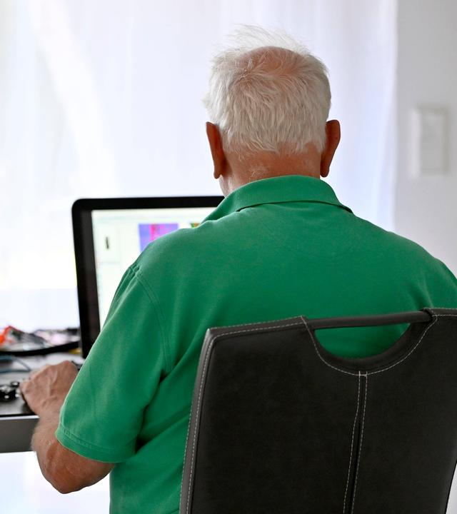 Ein Senior arbeitet in seiner Elektronik-Werkstatt im Home-Office.