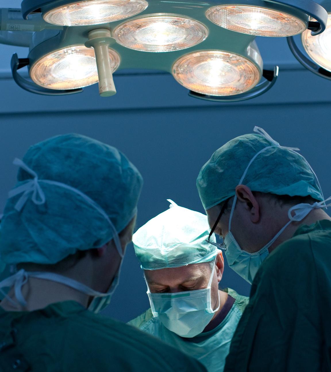 Ein Operation wird von Chirurgen unter OP-Licht durchgeführt.