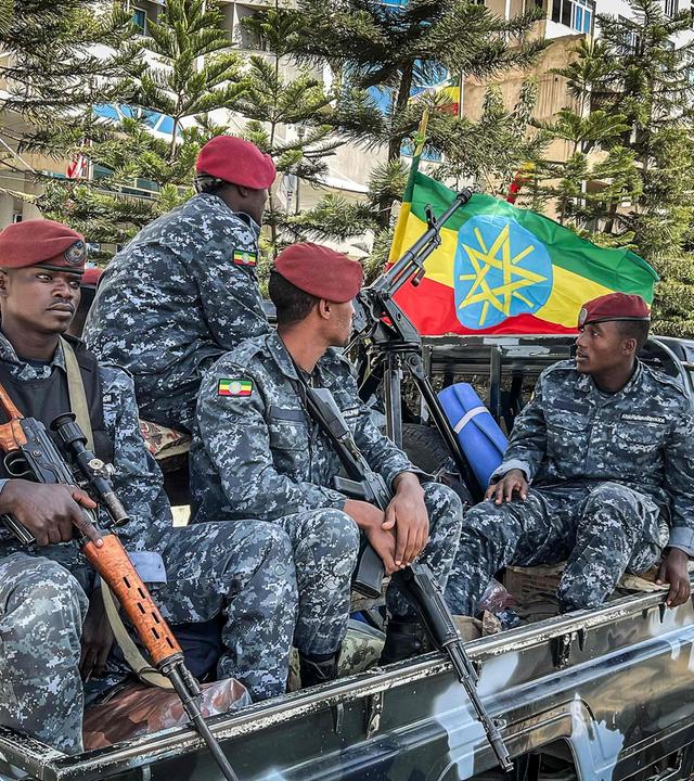 Bewaffnete Männer der Äthiopischen Staatspolizei (Ethiopian Federal Police) sitzen auf der Ladefläche eines Trucks, im Hintergrund weht die äthiopische Flagge.